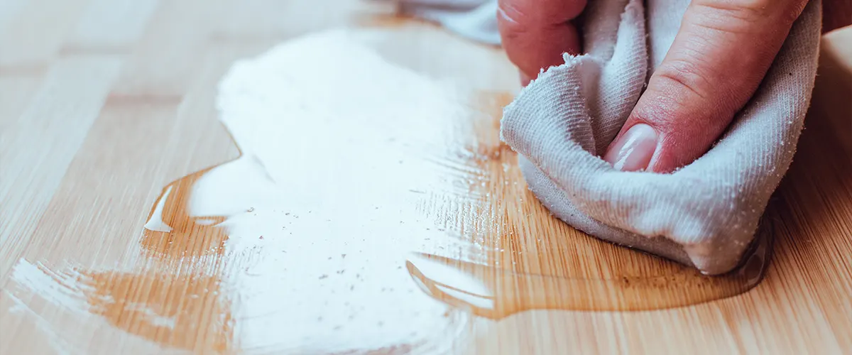 Contractor refinishing flooring with an oil-based finish and a cloth