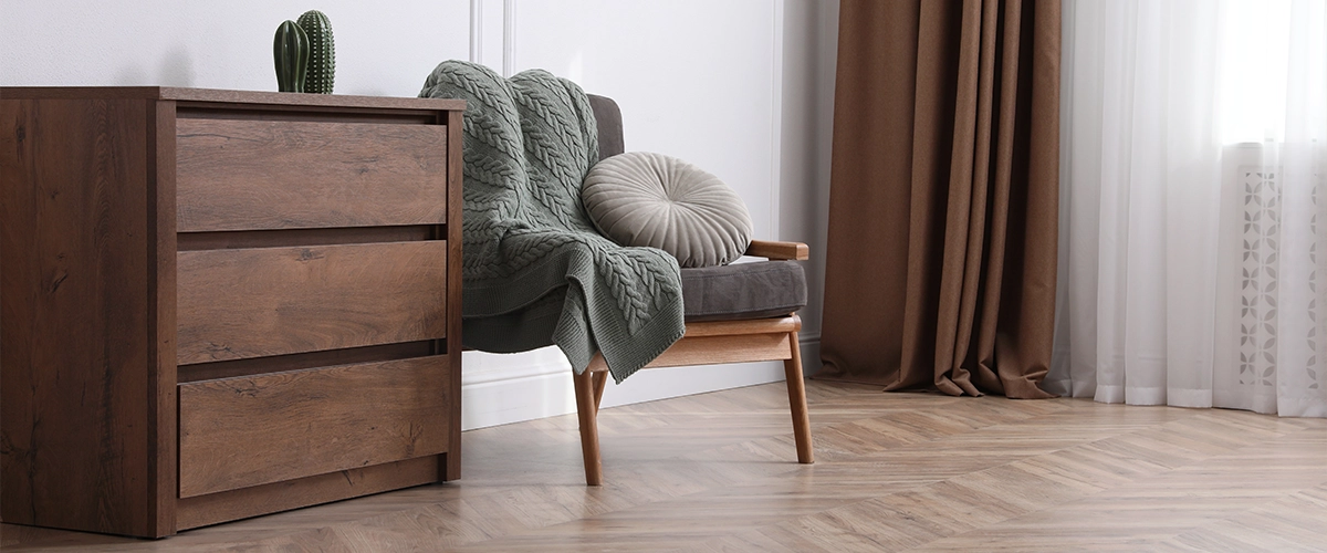 A beautiful herringbone hardwood floor with a hardwood cabinet