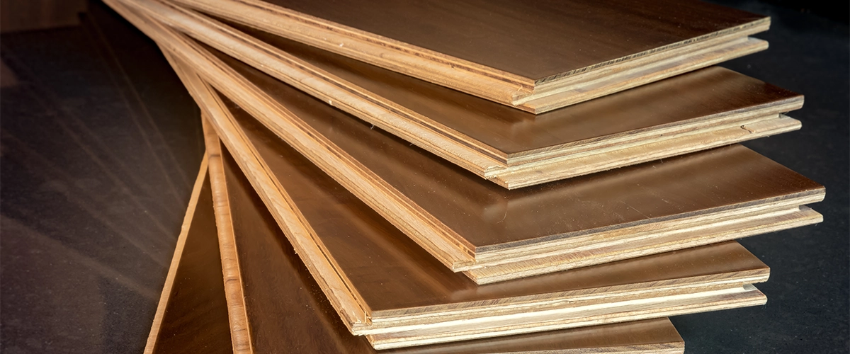 The engineered hardwood and hardwood difference with a stack of boards