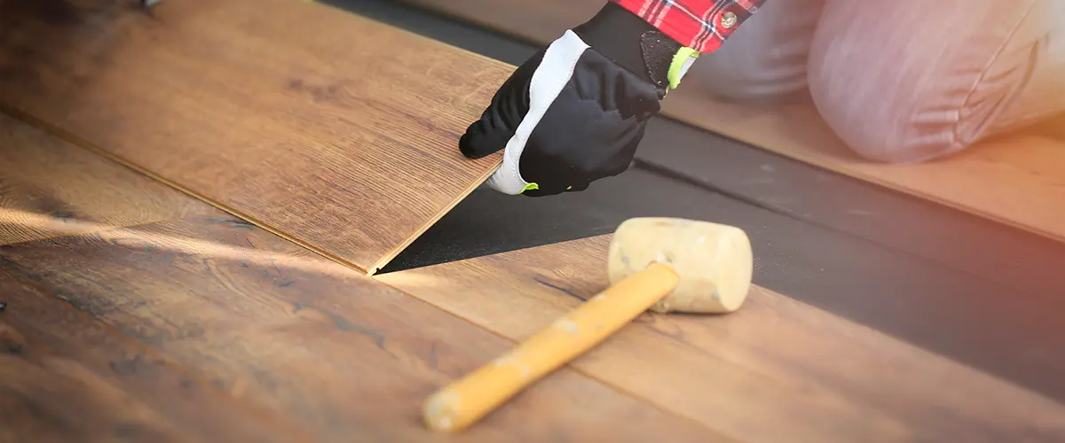 Prefinished hardwood floor installation with a wood mallet