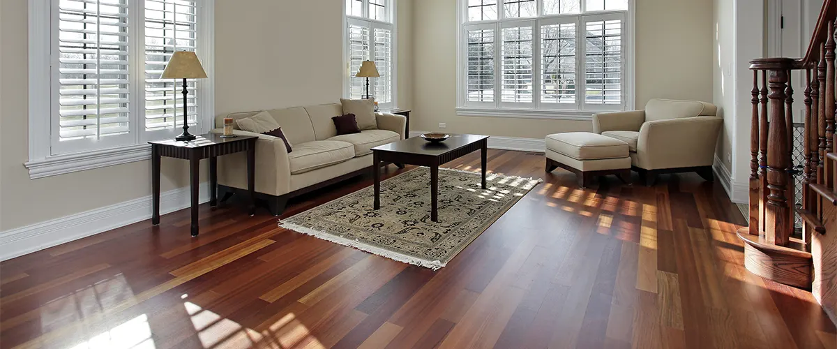 A hardwood floor in a living room with a beige chair