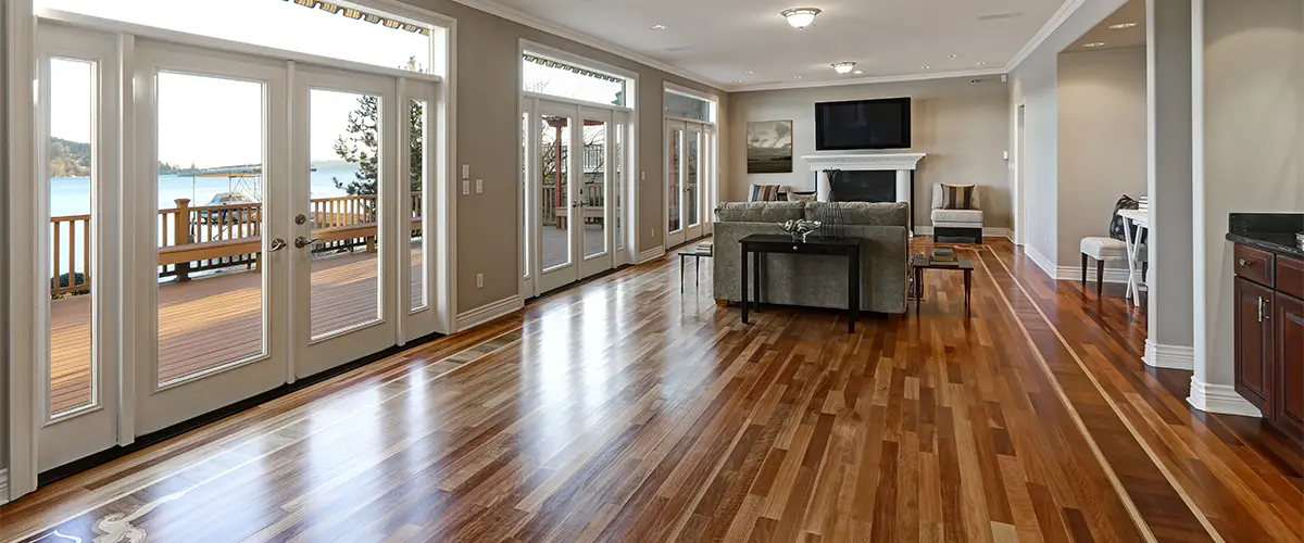 Hardwood flooring restoration in a room with large windows