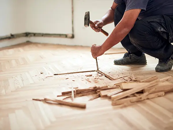 A flooring contractor taking out old floorboards