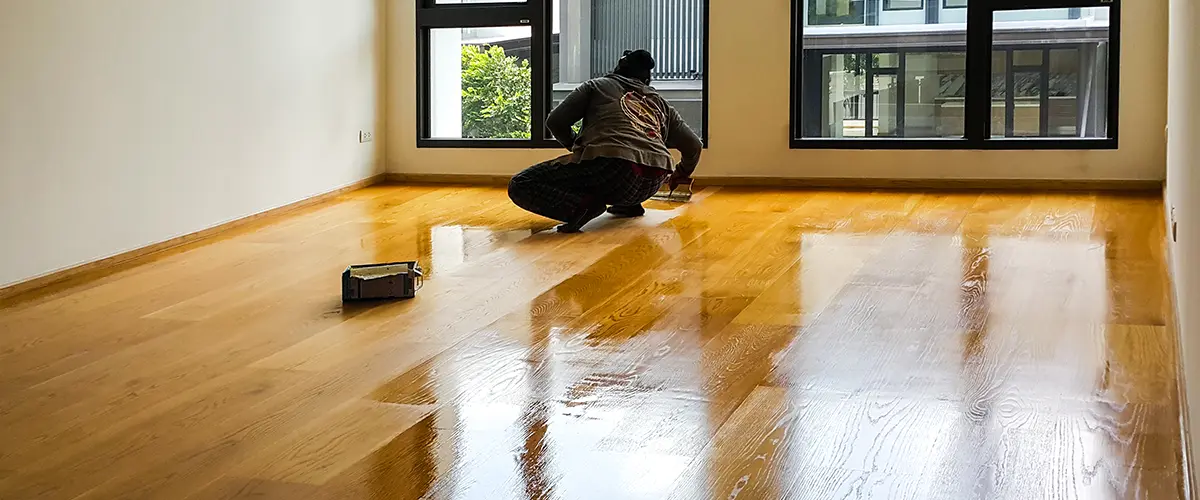 A man doing a hardwood floor refinishing project