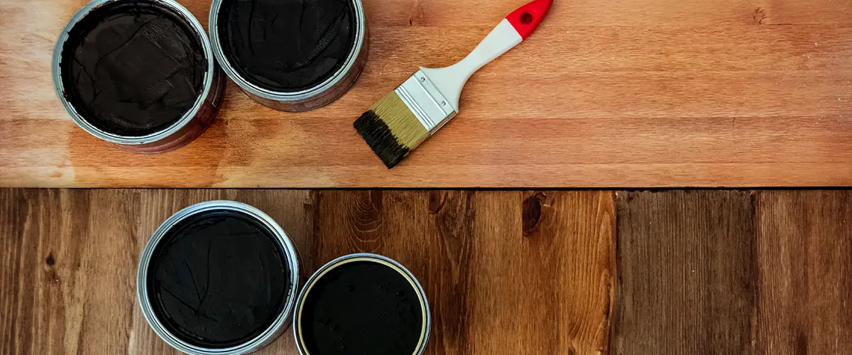 Hardwood floor refinishing with a brush and four cans of sealants