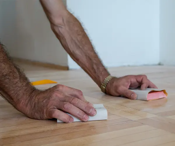 A man sanding wood floors