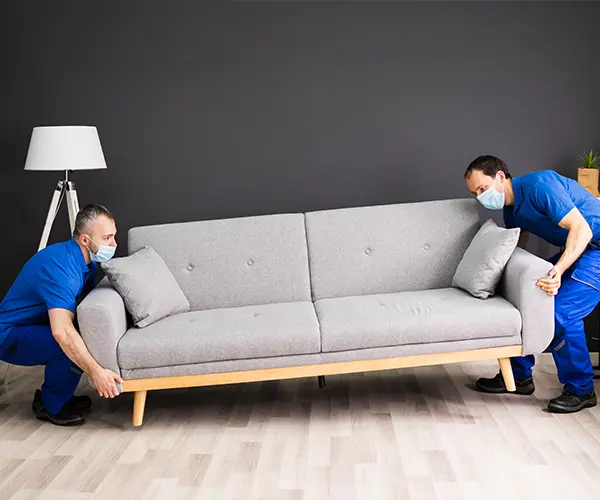 Two contractors lifting a couch
