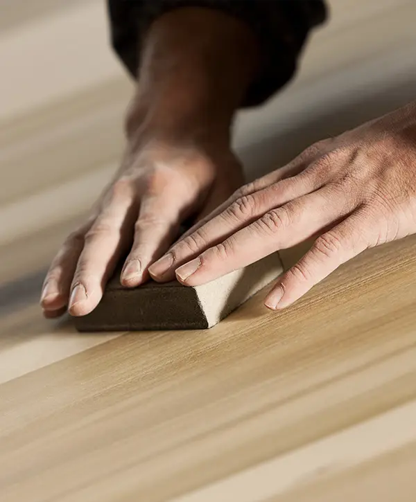 A man sanding a wood floor