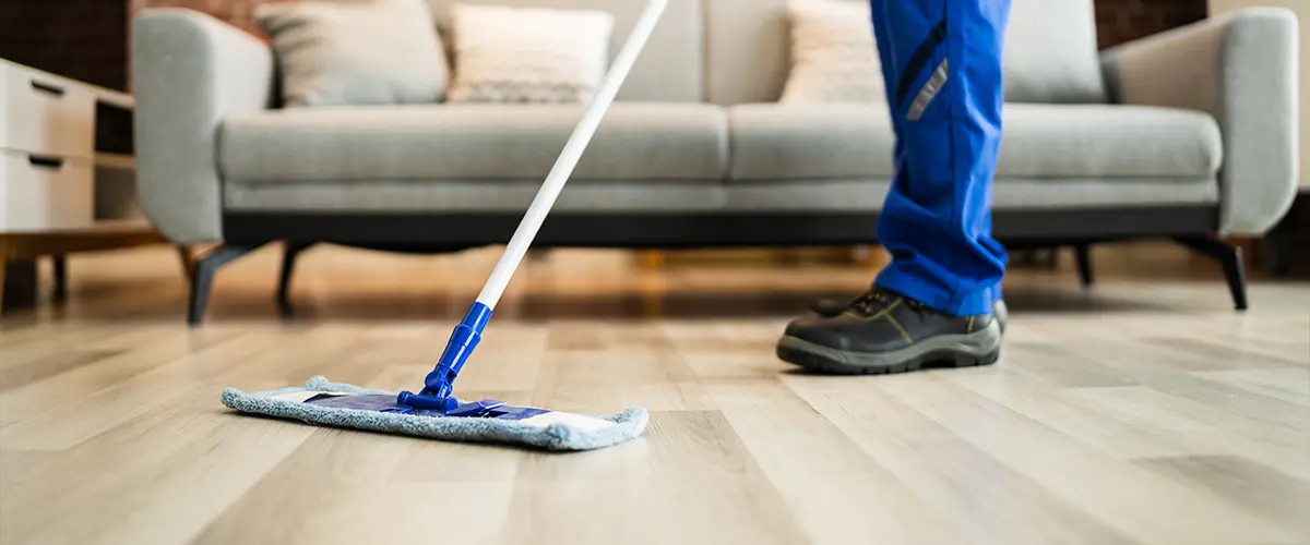 A contractor cleaning wood floor with microfiber mop