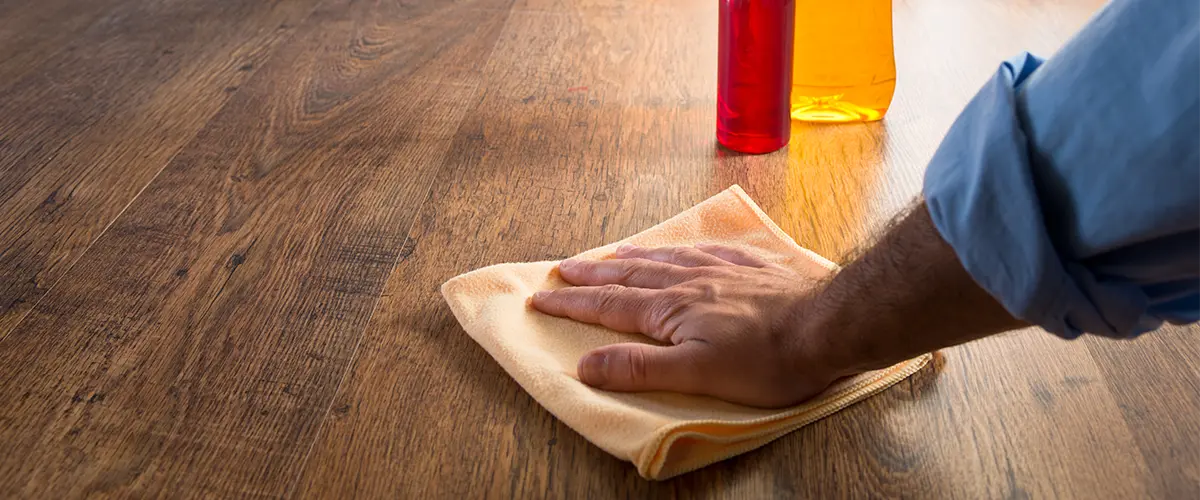 A man using a dry cloth to wipe floors