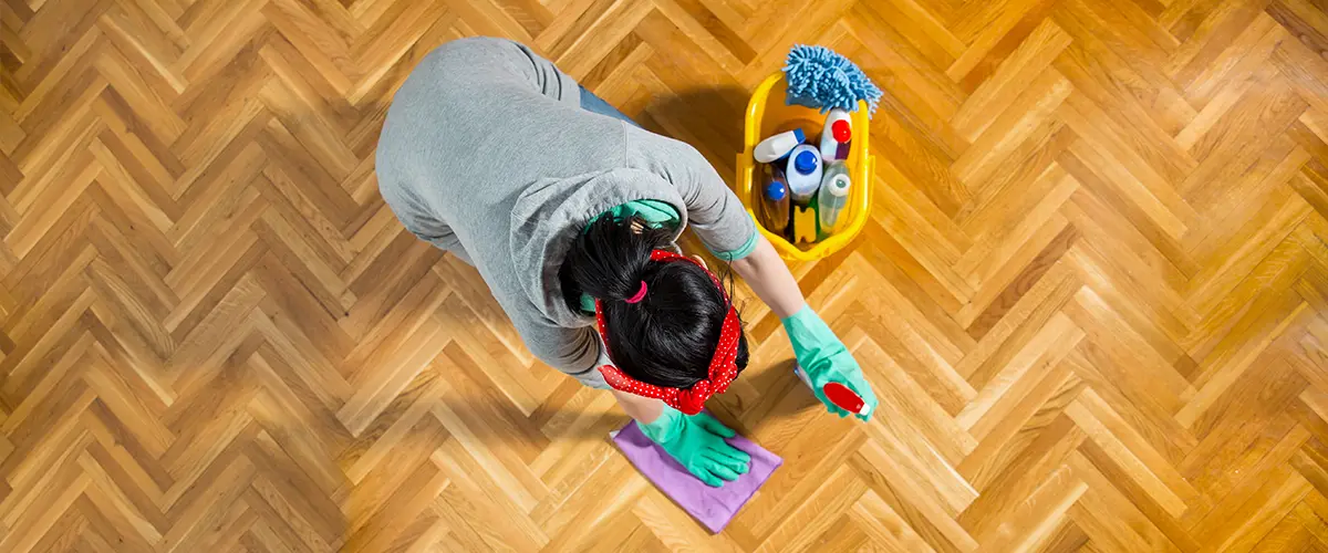 A homeowner cleaning a hardwood floor with Murphy's Oil Soap vs Bona products