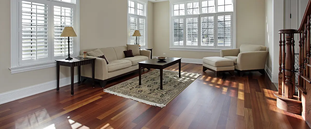 A living room with wood flooring and a white couch with a small table